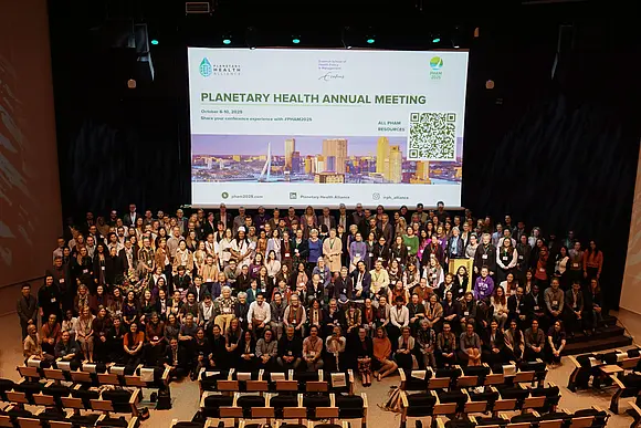 große Menschengruppe auf einer Bühne vor einer Leinwand