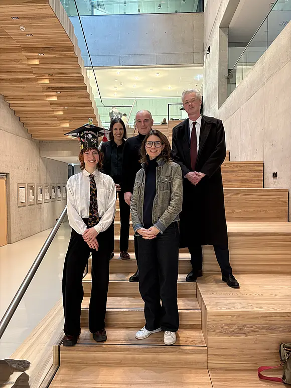 Five people on a wooden staircase