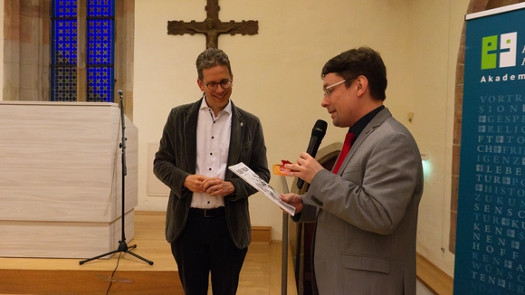 Niklas Wagner überreicht Dr. Stefan Einsiedel eine Sonderausgabe des Eulenfisch