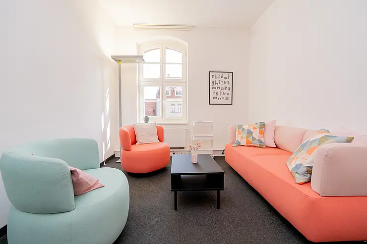 Der Beratungsraum mit 2 Sesseln und einem Sofa in hellen Tönen gehalten