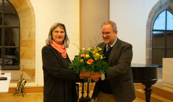 Der Dekan überreicht Maria Widl einen Blumenstrauß bei ihrer Abschiedsvorlesung