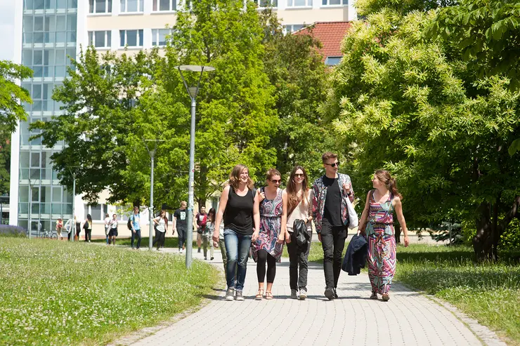 Studierende laufen über den Campus