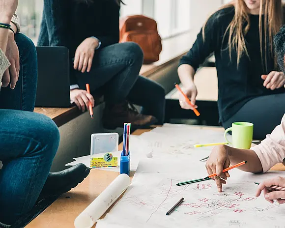 eine kleine Gruppe arbeitet zusammen am Tisch
