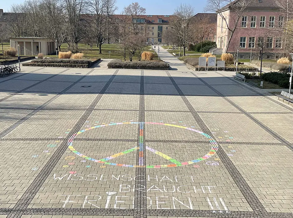 Peace-Zeichen mit Straßenmalkreide am Eingang zur Universität Erfurt
