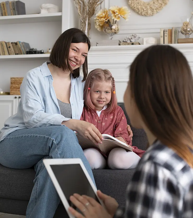 Eine kjunge Fraue berät eine Mutter mit ihrem Kind