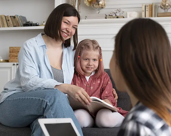 Eine JUnge Frau berät eine Mutter mit ihrer kleinen Tochter
