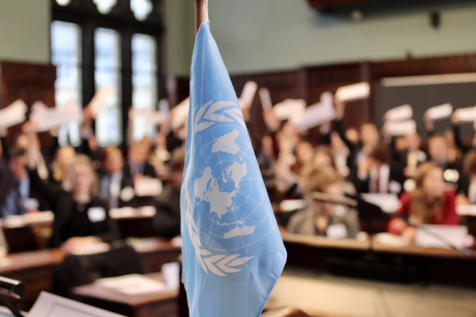 UN-Flagge vor abstimmenden Personen