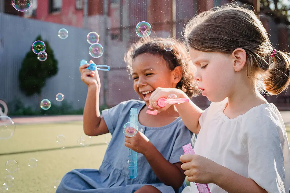 two girls making soap bubbles