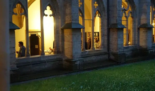 Kreuzgang von außen gesehen mit Personen, die sich unterhalten