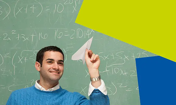 a man with a paper aeroplane in front of a blackboard