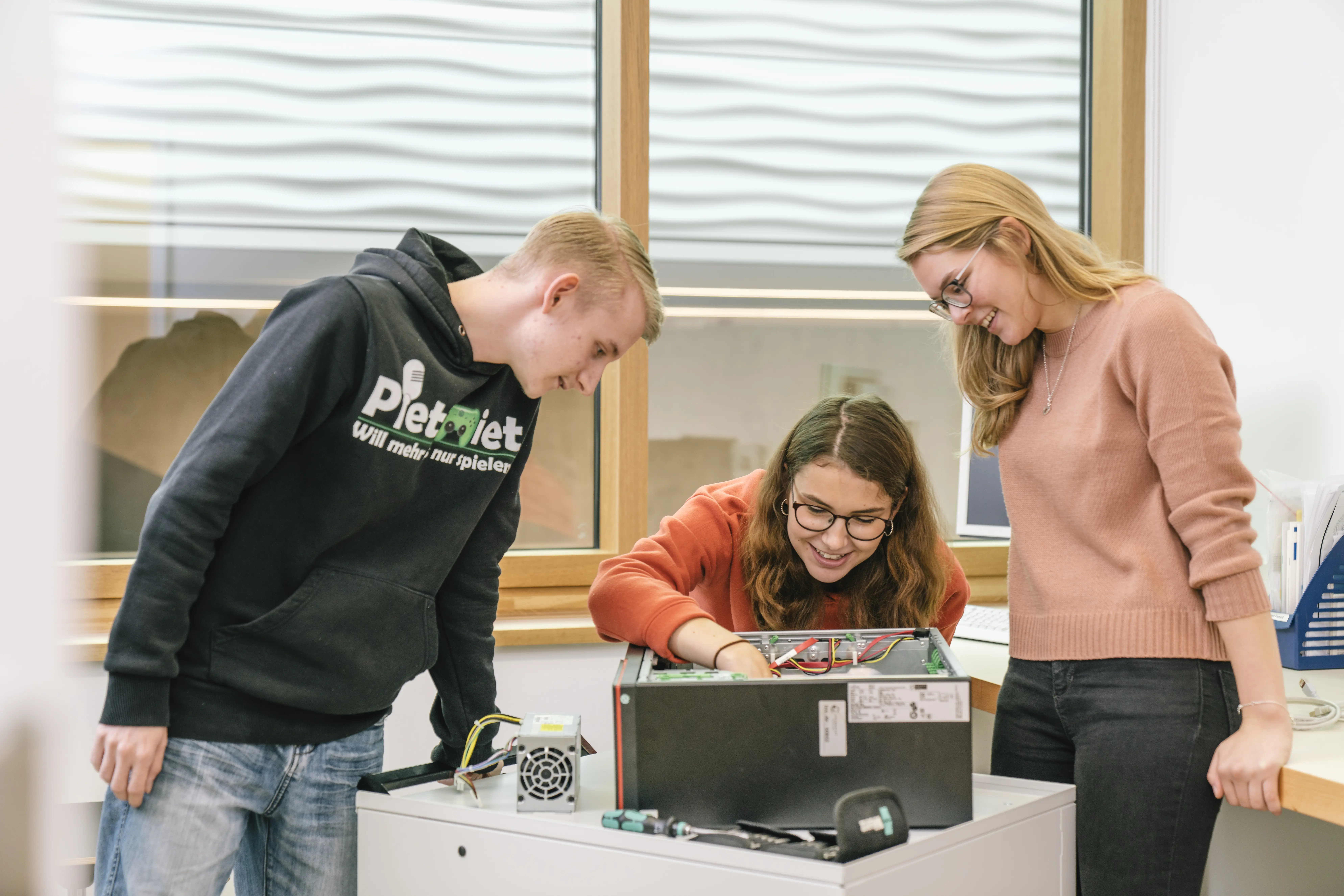 young people working on the inside of a computer