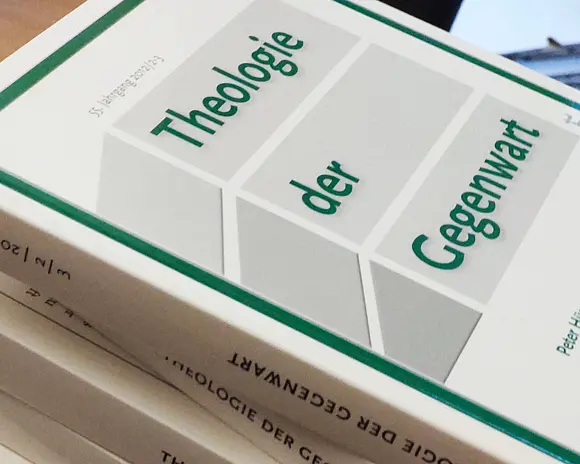 Mehrere Ausgaben "Theologie der Gegenwart" liegen auf einem Tisch