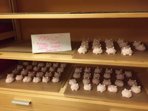 Die fertigen Salzteig-Schweine stehen zum Trocknen im Regal (Vergrößerung des Spiels "Pig Hole" für Schüler:innen mit sonderpädagogischem Förderbedarf)