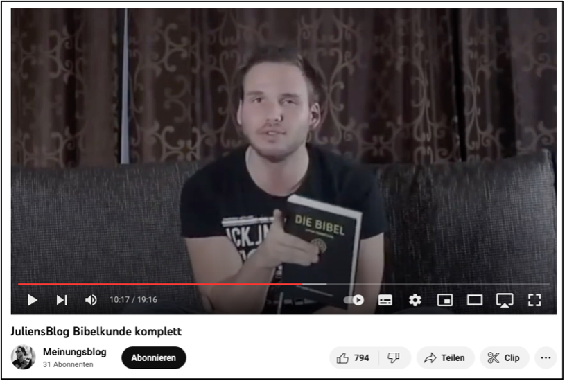 Screenshot eines der Videos von JuliensBlog, indem er der Kammer zugewandt etwas erklärt und mit den Händen gestikuliert.
