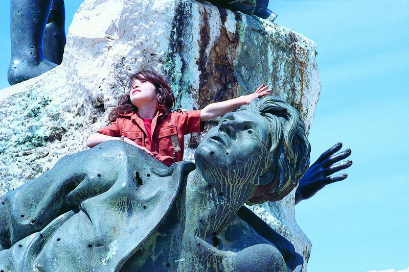 Ein Mädchen auf einer Statue 